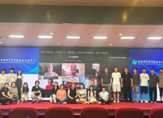 Bergrettung im Austausch / Kulturforum Peking Teilnehmende im Hörsaal des RCEES-CAS beim Gruppenfoto; auf der Leinwand im Hintergrund per Video zugeschaltete Expertinnen und Experten.