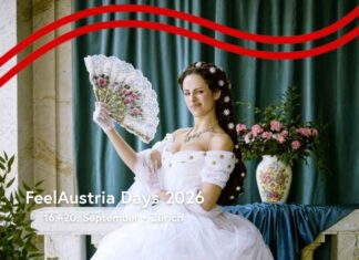 FeelAustria Days / Kulturforum Bern Das Bild ist das Werbemotiv der FeelAustria Days 2026. Zu sehen ist eine moderne Parodie auf Kaiserin Sissi: Eine Person steht in einem weißen, prunkvollen Kleid vor einer kunstvoll gestalteten Kulisse im Barockstil. Sie hält einen Fächer in der Hand und posiert bewusst unkonventionell. Ihr Gesichtsausdruck wirkt lässig und leicht übertrieben, mit einem kleinen, schelmischen Zug, während sie direkt in die Kamera blickt. Im Vordergrund steht in weißer Schrift der Text: „FeelAustria Days 2026 – Von 16. bis 20. September in Zürich“.