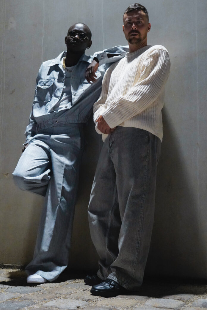 Das Bild zeigt die beiden Künstler C-Tea und Andi Stecher in lässiger Pose stehend.