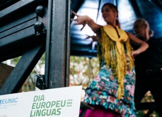 Europäischer Tag der Sprachen / Botschaft Lissabon Zwei Personen tanzen bei einer Veranstaltung. Im Vordergrund steht ein Schild zum Europäischen Tag der Sprachen.