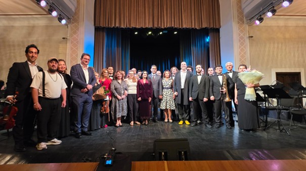 Das Bild zeigt Markus Geiselhart und das Estrada-Symphonieorchester gemeinsam mit dem österreichischen Botschafter Etienne Berchtold nach dem Konzert.